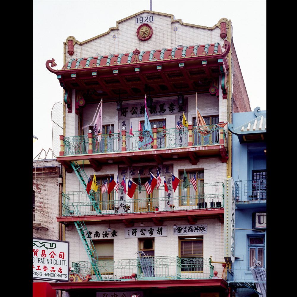 Photo of a historic building in San Francisco displaying mulitple flags, Chinatown.